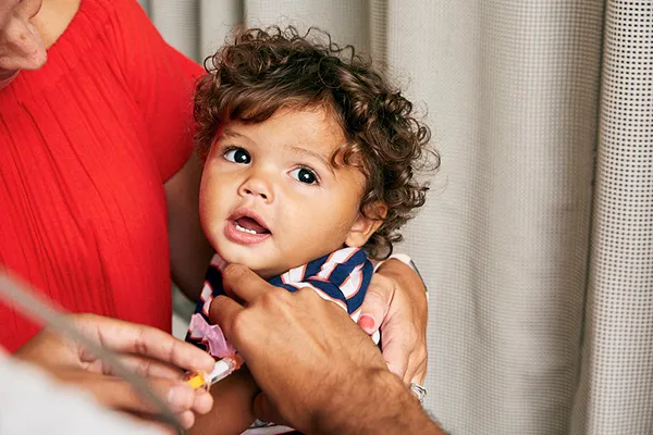 Toddler recieves a vaccine in his arm