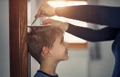 Parent measuring child's height. Credit: iStock.com