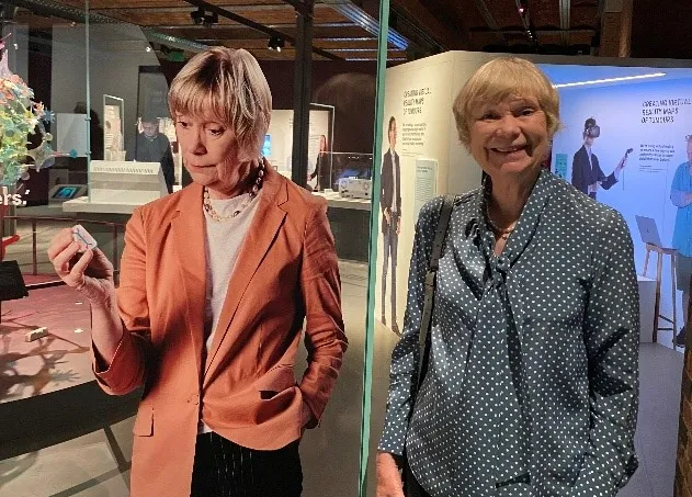 Professor Fran Balkwill standing beside the CanBuild project display at the opening of Cancer Revolution: Science, innovation and hope