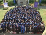 Students posing for photo on lawn after graduating