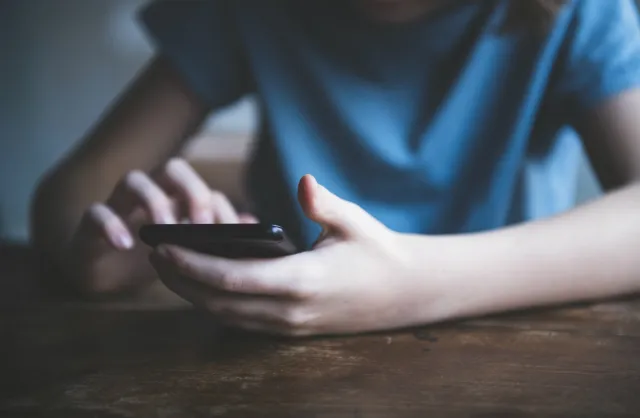 Boy using phone. Credit: Rouzes/iStock.com
