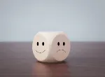 Happy and sad symbols on wooden blocks. Credit:Chaiwiwat Duangjinda/iStock.com