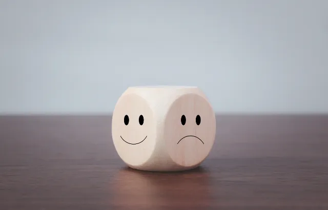 Happy and sad symbols on wooden blocks. Credit:Chaiwiwat Duangjinda/iStock.com