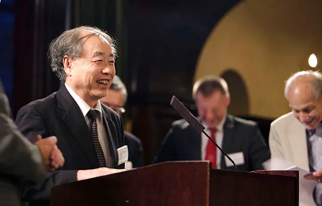 Makoto Kobayashi accepting a copy of the book
