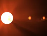 Artistic representation of a low-mass star and planets (not to scale): The red-hue colour tries to reproduce the colour of the ambient light a human might perceive on planets around such red-stars.