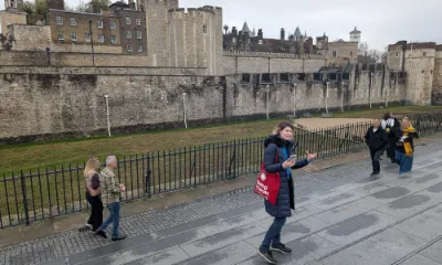 Jaclyn Rajsic stands outside of the Tower of London, wearing a Being Human Festival tote bag