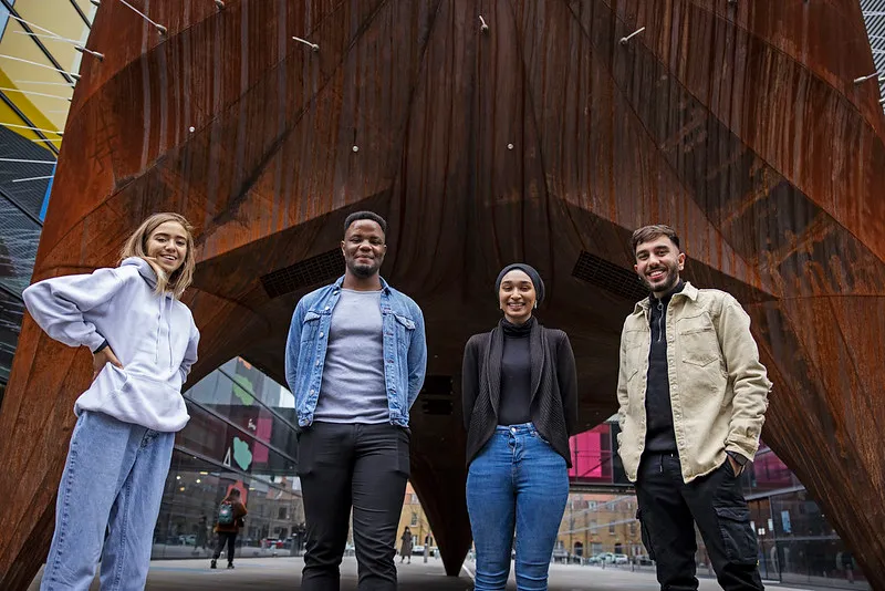 Four students standing together, smiling