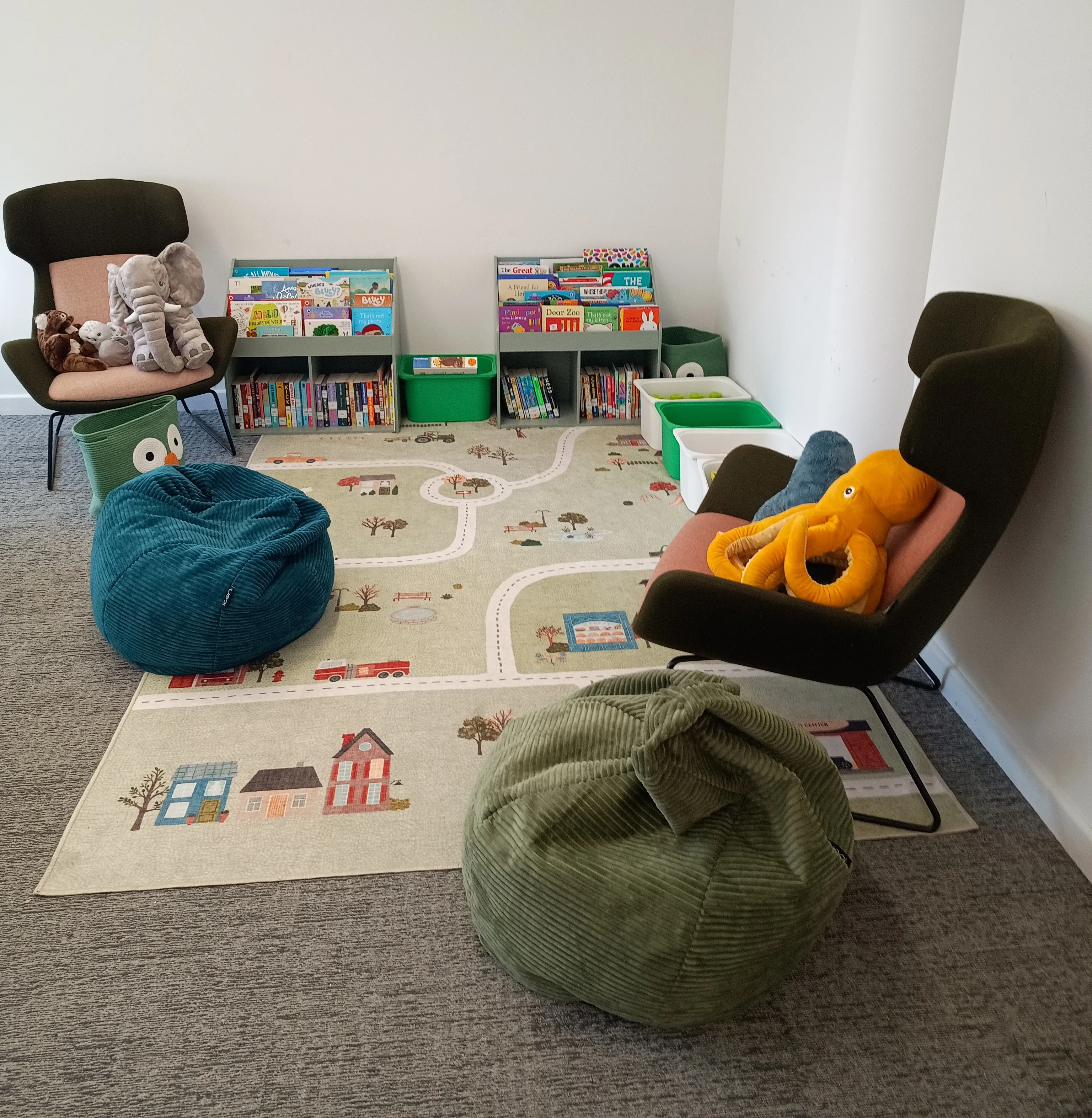 Interior of Family Room with seating, a rug and books on a shelf
