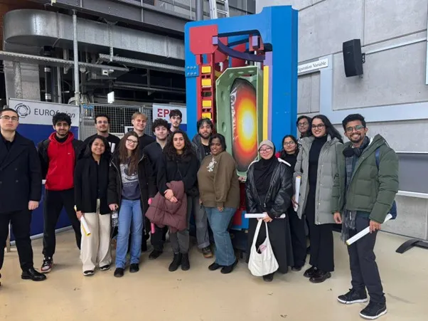 Students stand in front of colourful specialised research equipment