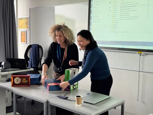 Two people exchange gifts to each other at a project inception meeting.