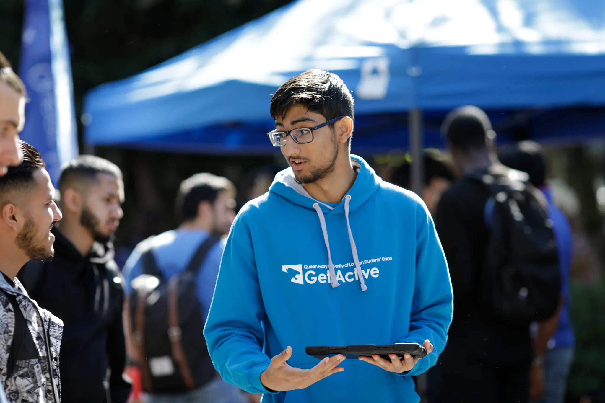 Student speaking to others while holding an ipad