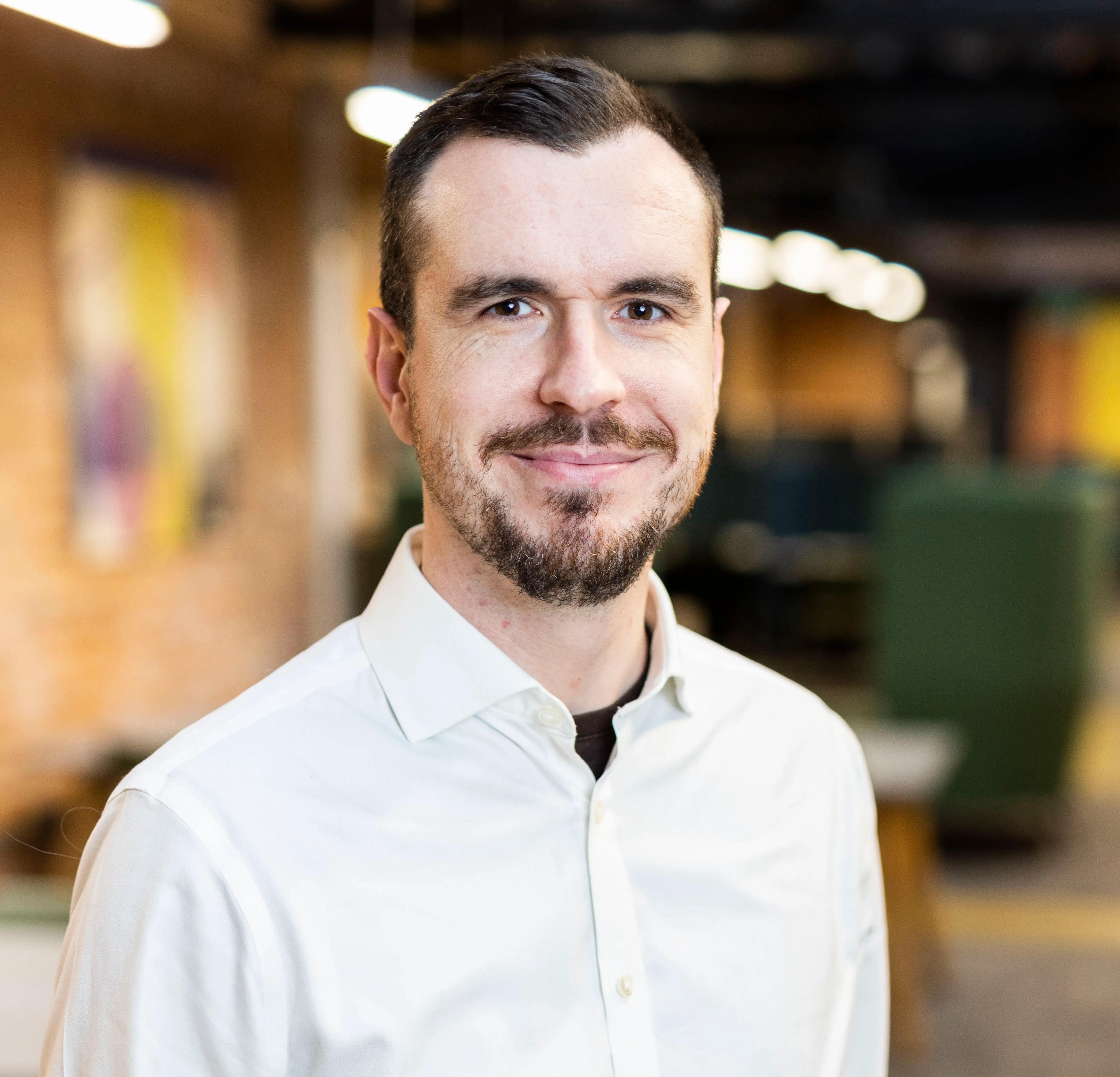 Photo of Jonathan Jackson in a white shirt looking at the camera smiling.