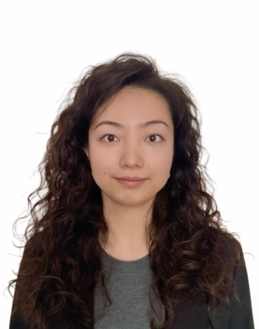 Headshot of Wenqing in grey top, looking at camera with a white background.
