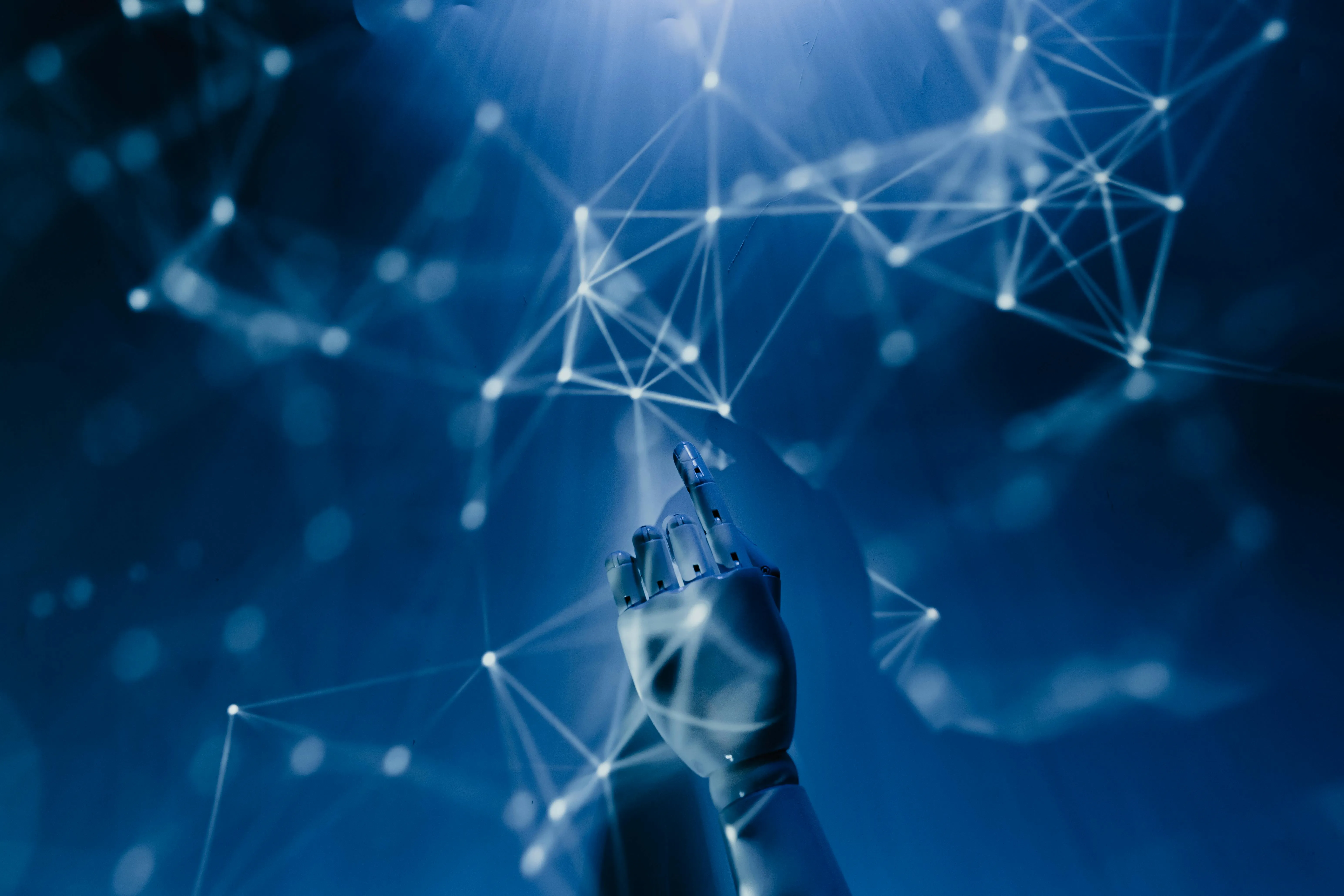 Robotic hand reaching toward a glowing digital network of nodes and lines on a dark blue background