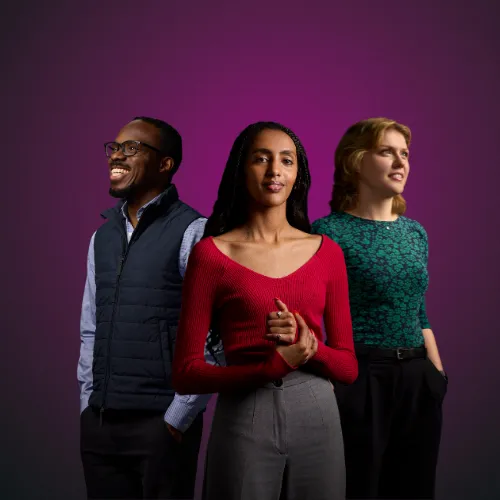 Three Queen Mary students from diverse ethnic backgrounds stand in front of a purple background.