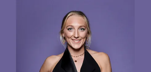 A picture of Saskia Budgett in smart dress against a purple background