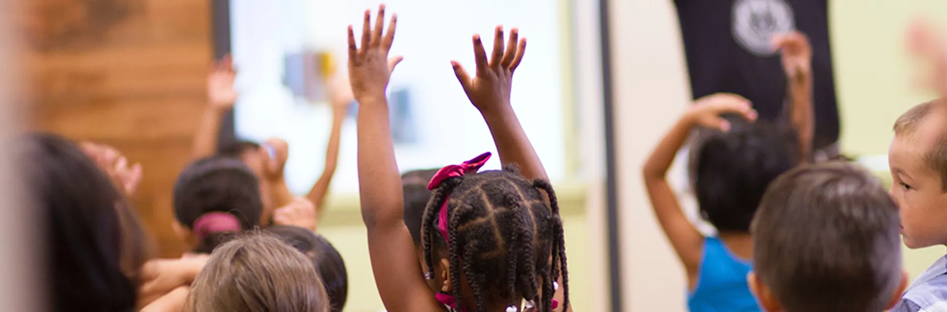 children playing putting their arms into the air