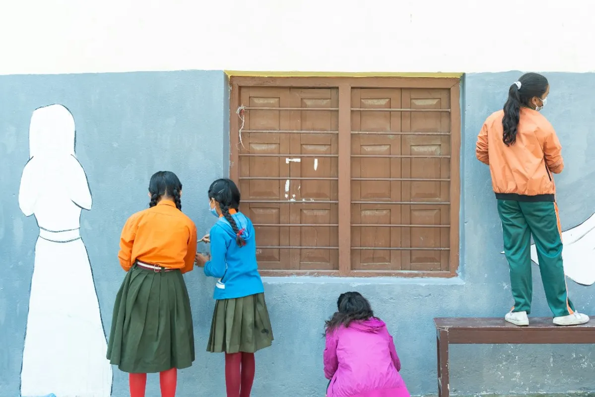 Girls painting a mural