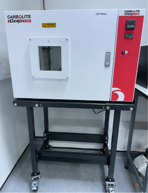 Red and white research oven, with a square glass viewing port, on a table. For temperature meausurements up to 600 degrees C.