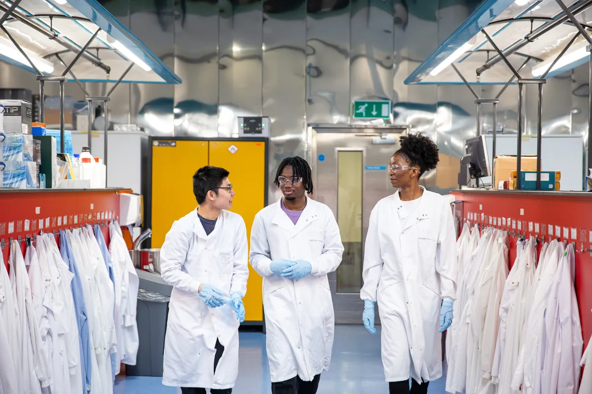 Three diverse students in a laboratory