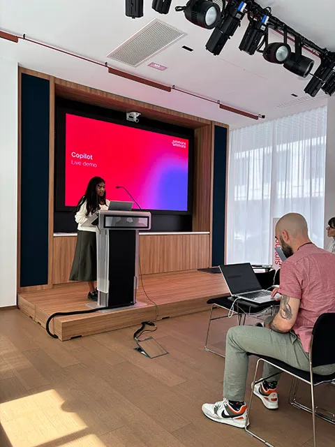 A student standing at a podium in front of a projection screen