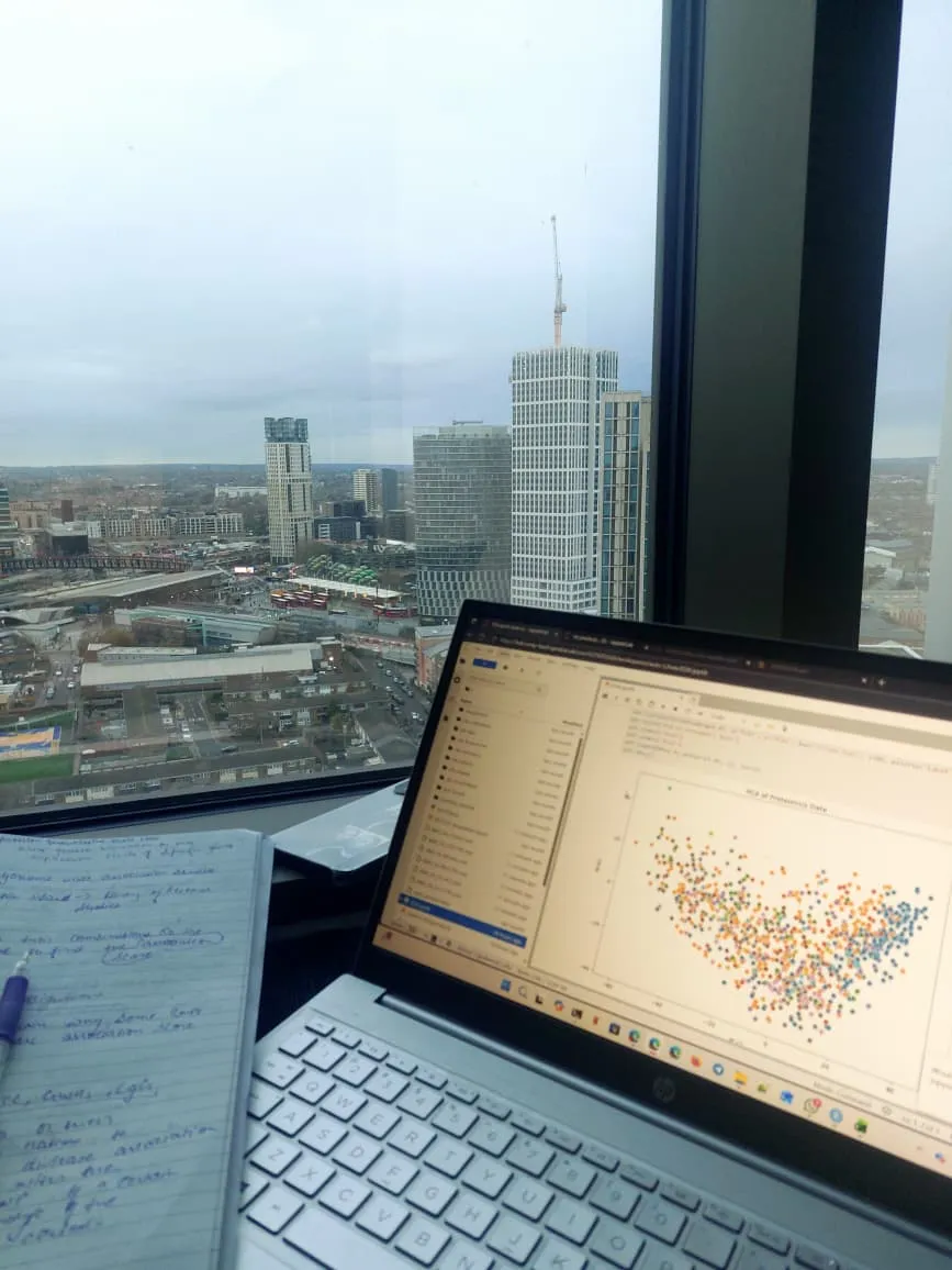 Image of a laptop screen with coding work, in the background is a london skyline