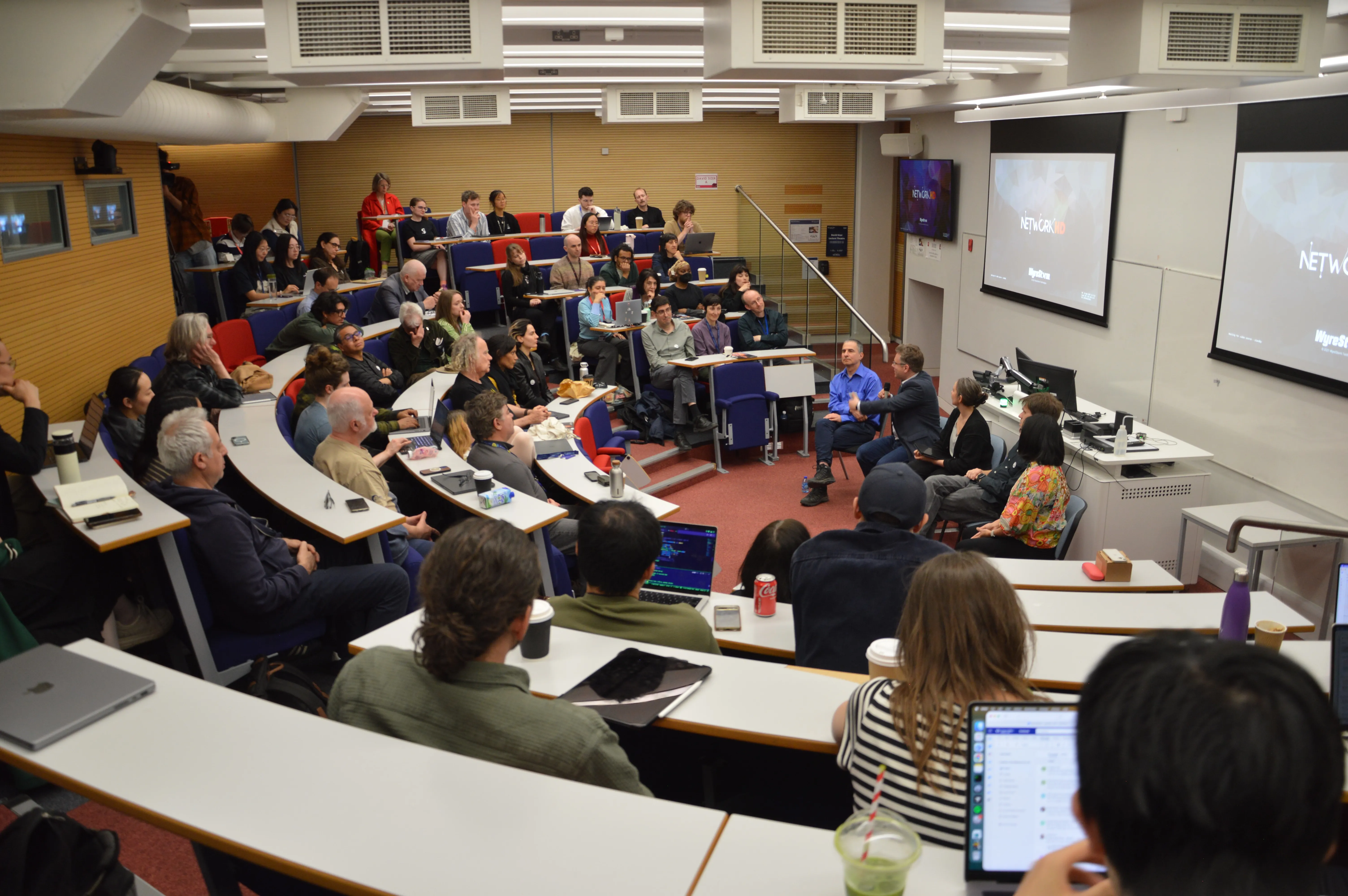 Group of academics and students listening to a panel