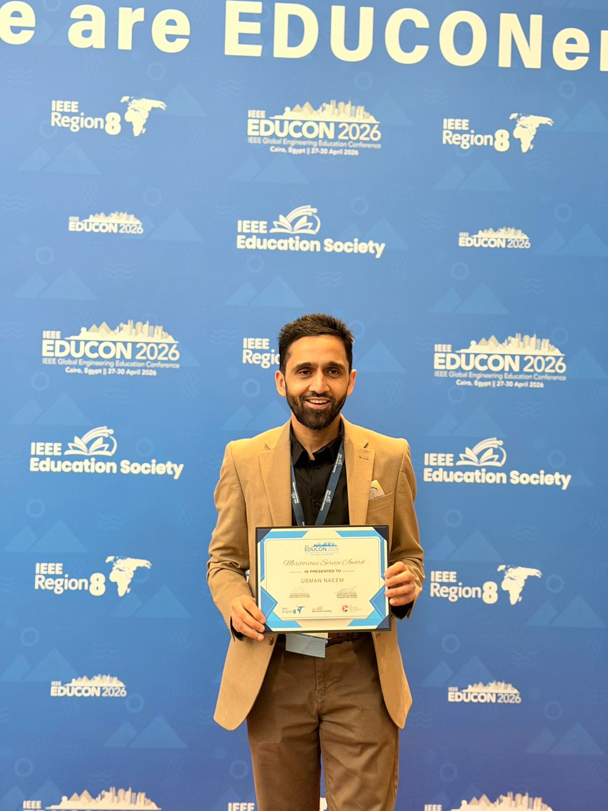 Usman Naeem at IEEE conference holding his award