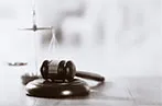 Black and white of a gavel resting on a bench in black and white
