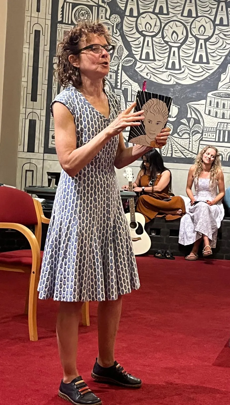 Actress performing in chaplancy with specators seated in background